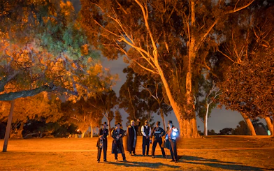 Group in period costumes on San Diego Ghosts & Gravestones Tour at night.