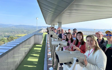 Tourists at DMZ Observatory using binoculars to view the landscape during Half Day DMZ Tour.