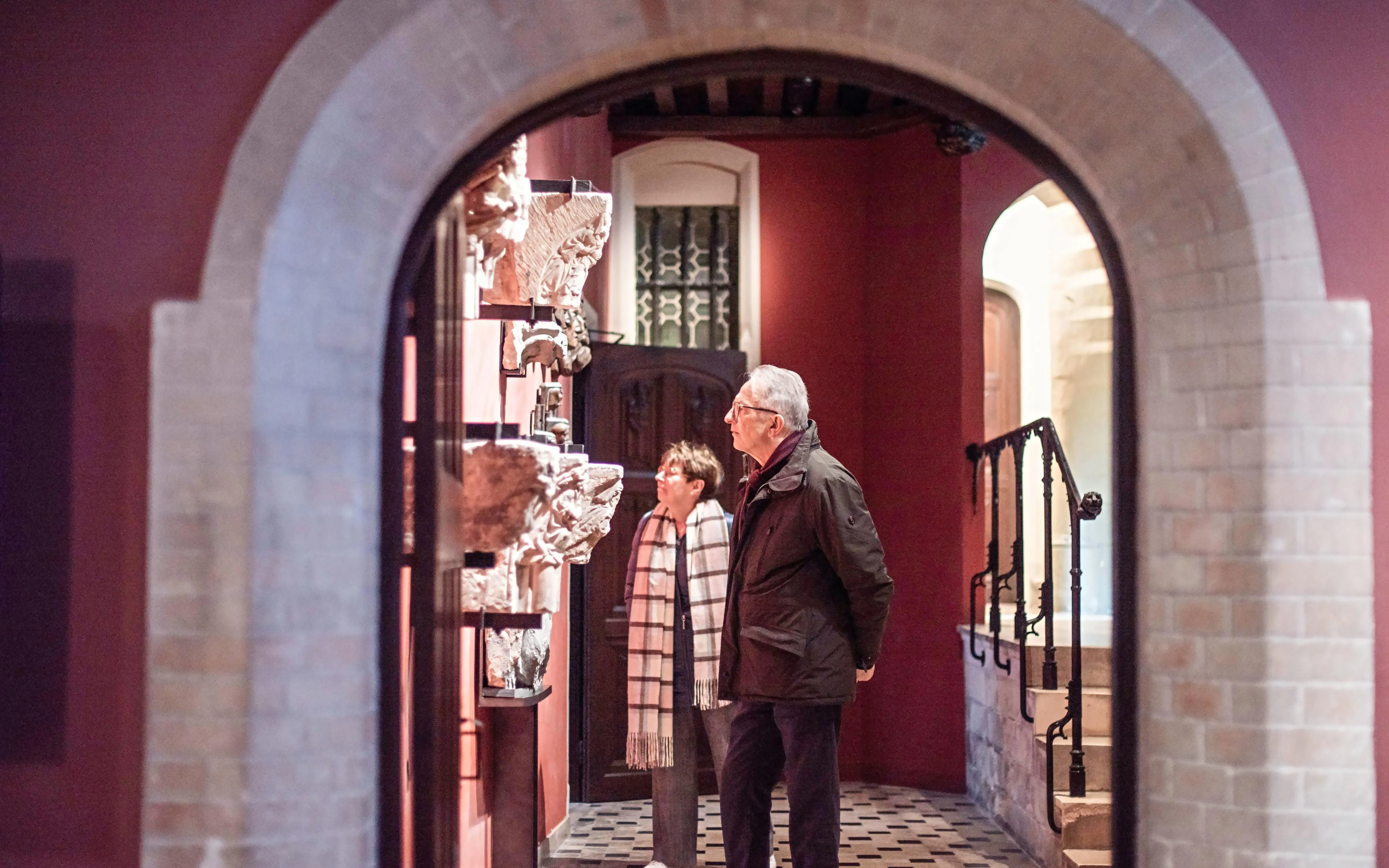 Visitors exploring sculptures at Gruuthusemuseum, Bruges.
