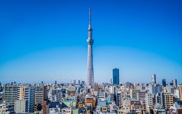 Tokyo Skytree towering over cityscape on a clear day.