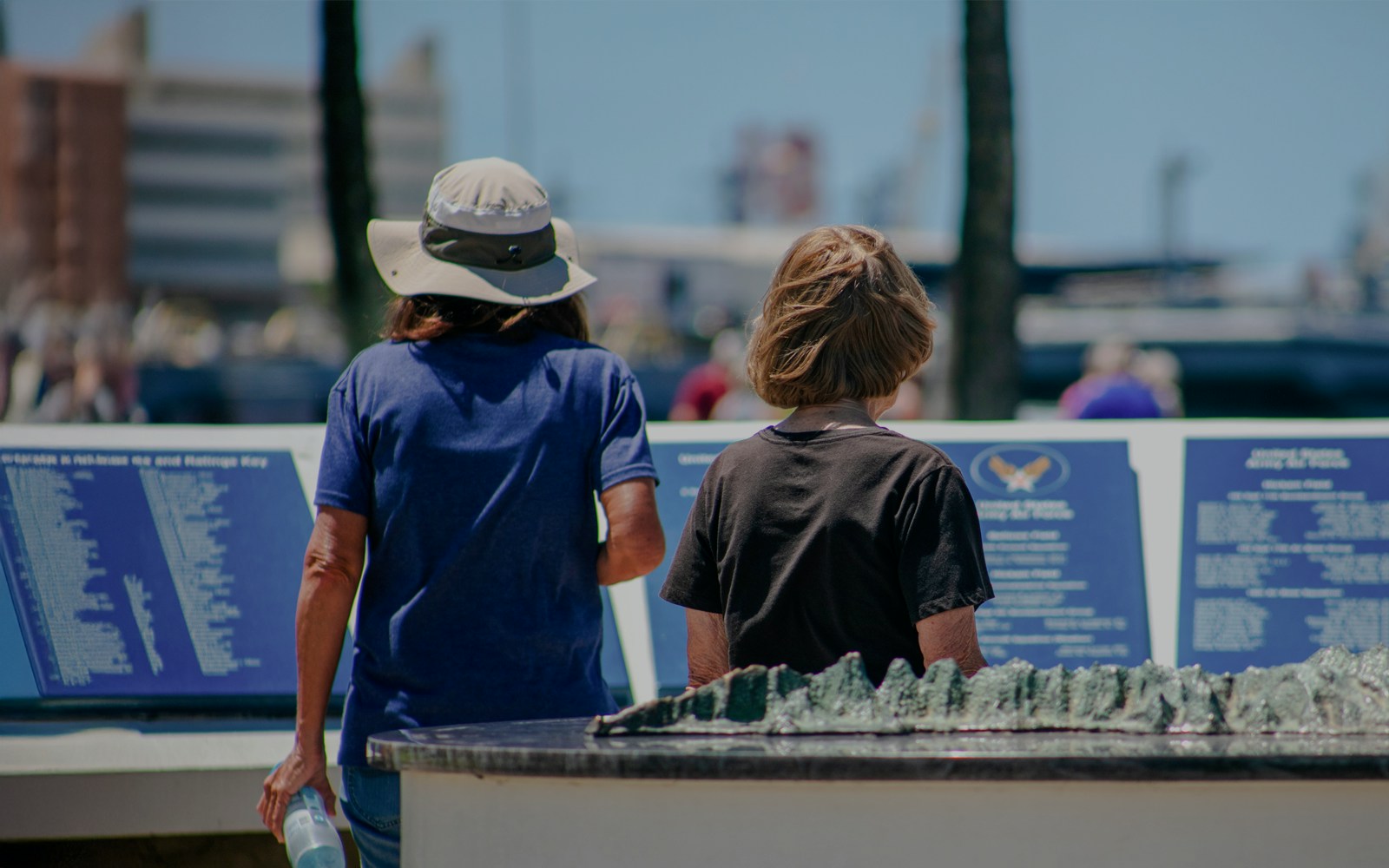 Mother and daughter reading plaques at Pearl Harbor Memorial Center.