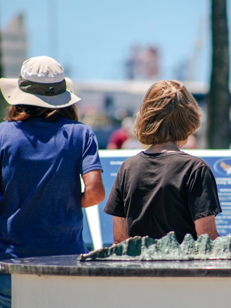 Mother and daughter reading plaques at Pearl Harbor Memorial Center.