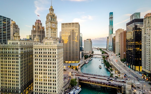 Chicago skyline with Wrigley Building and Chicago River at sunset.