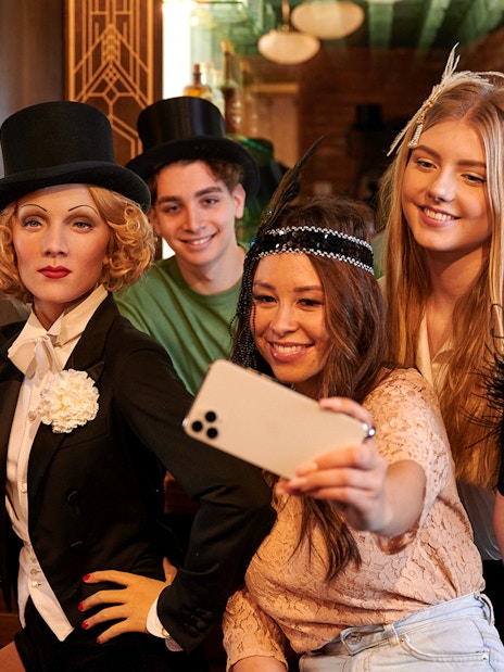 Visitors taking a selfie with Marlene Dietrich wax figure at Madame Tussauds Berlin.