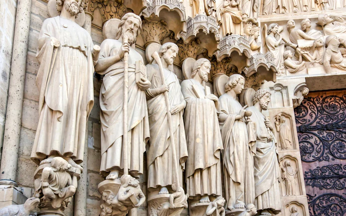 Stone statues of saints on the facade of Notre-Dame Cathedral in Paris.