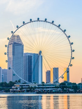 Singapore Flyer with city skyline at sunset, view from Marina Bay.
