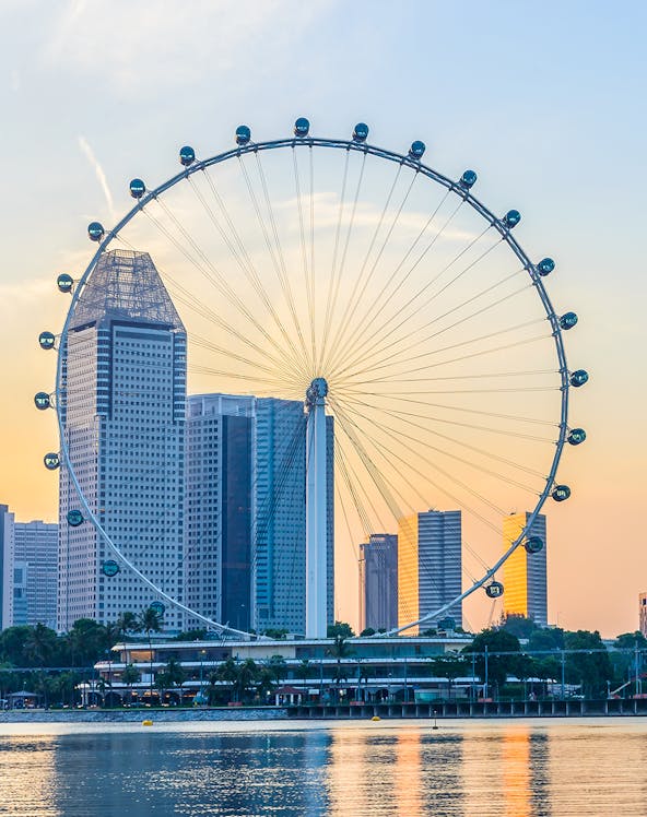 Singapore Flyer with city skyline at sunset, view from Marina Bay.
