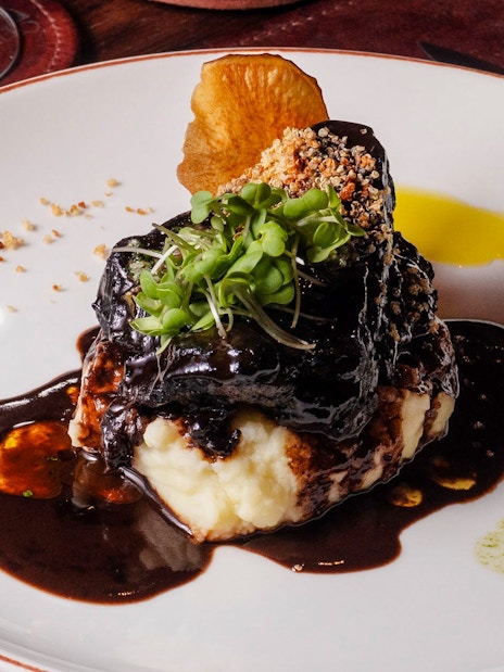 Balsamic-braised pork spare ribs with garnish at Michelangelo Tango Show.