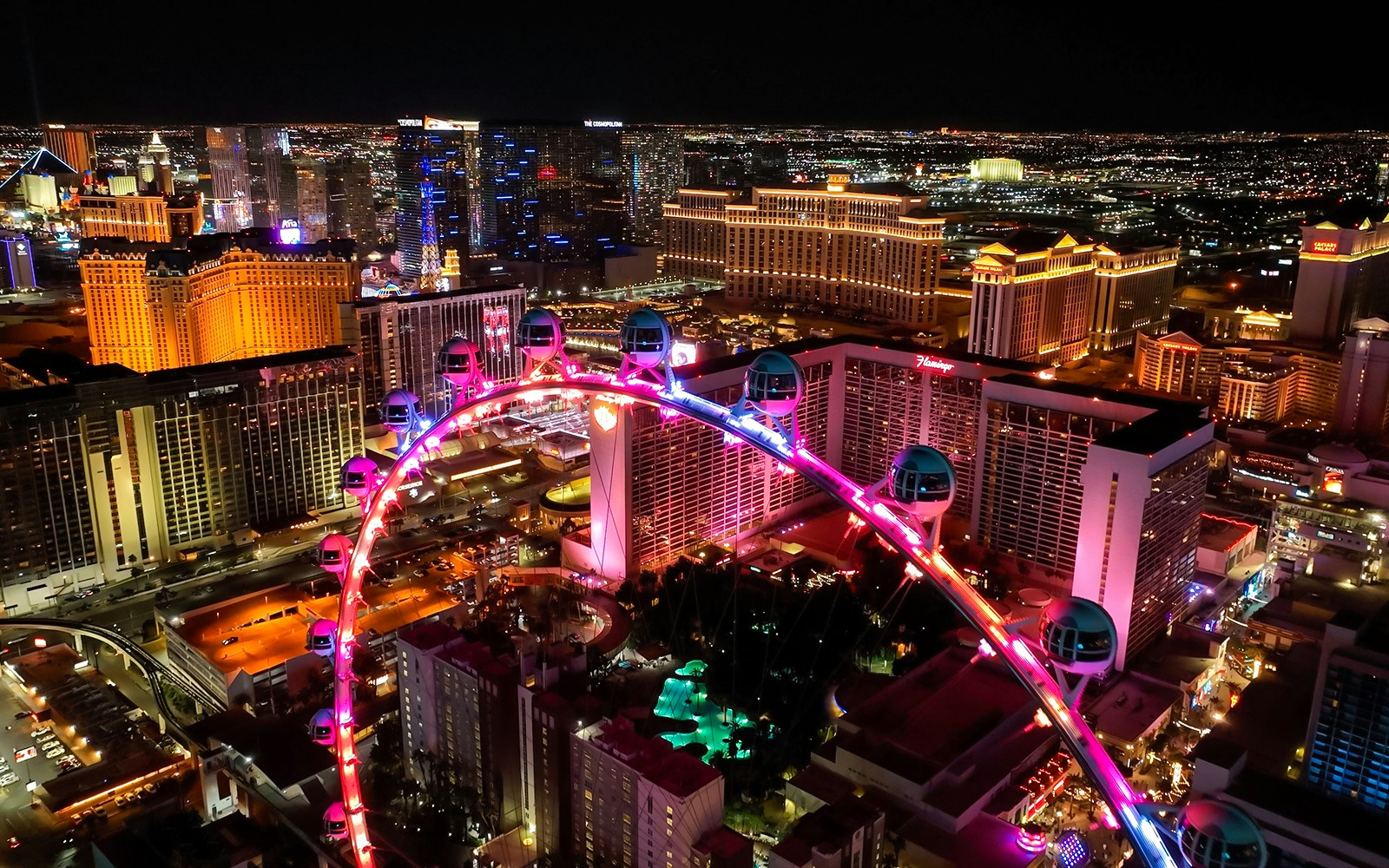 High Roller Ferris wheel illuminated at night in Las Vegas, Nevada with city skyline.