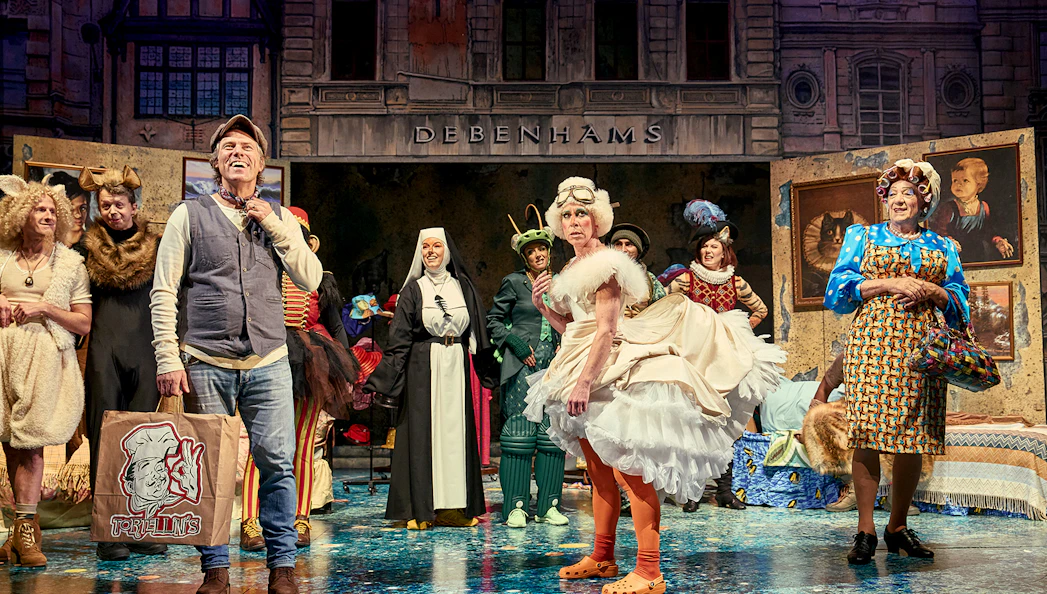 Theater cast in colorful costumes performing "Mother Goose" on stage.