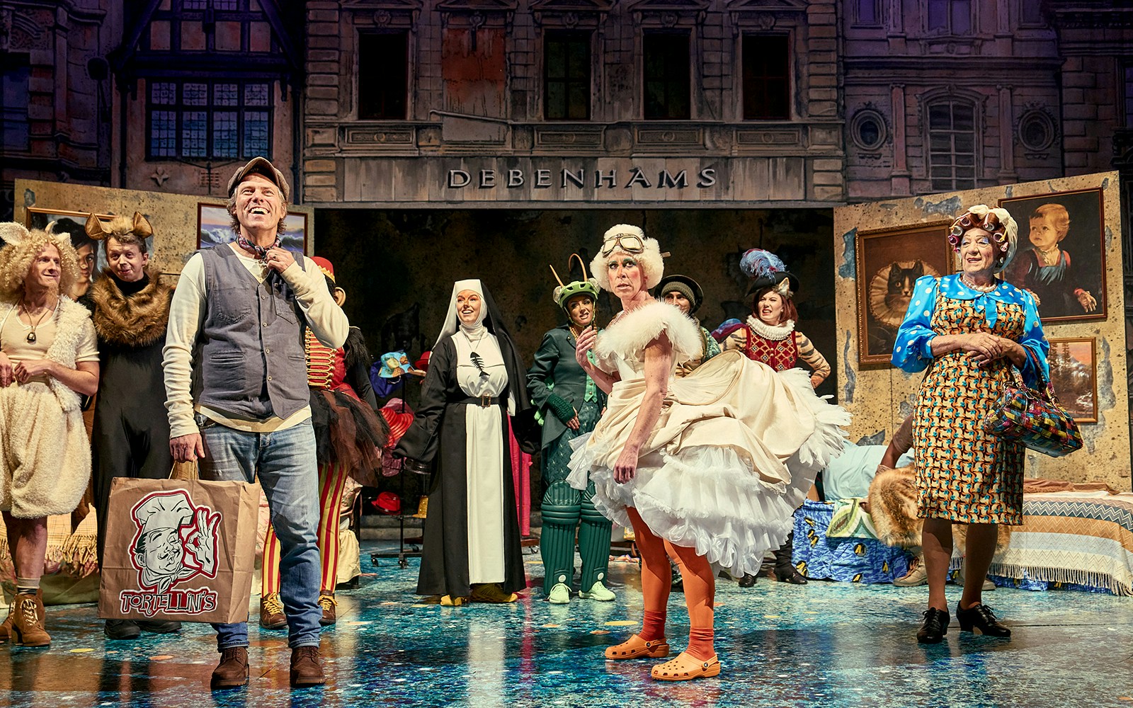 Theater cast in colorful costumes performing "Mother Goose" on stage.