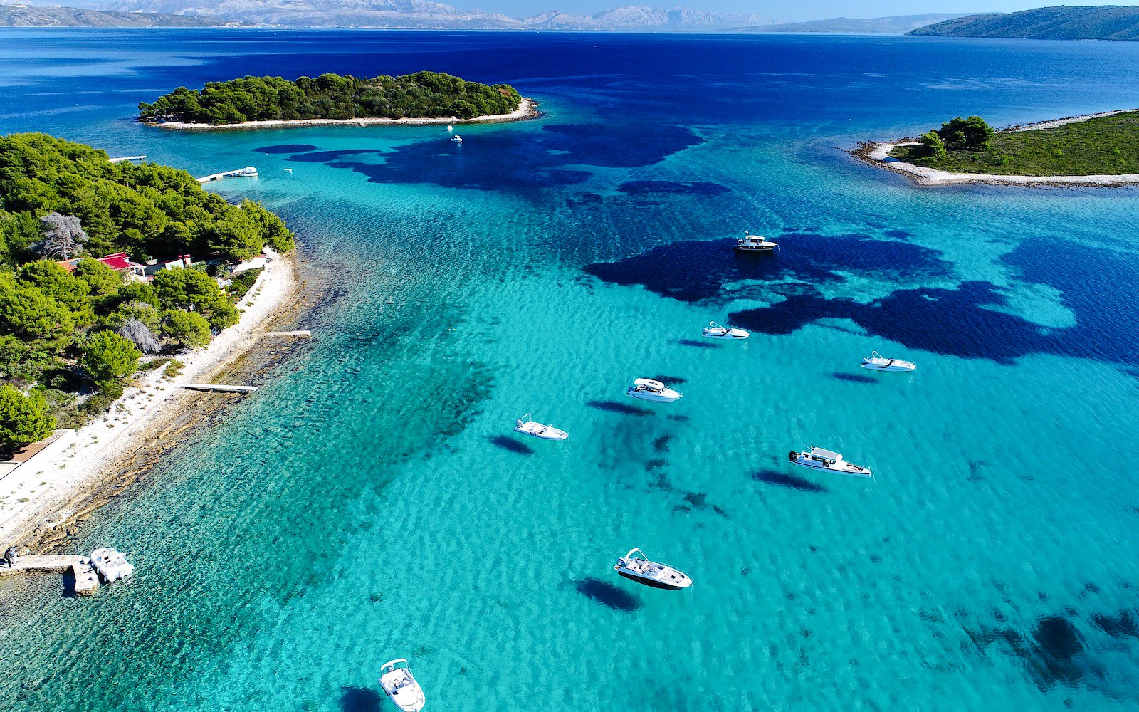 Aerial view of the Blue Lagoon with speedboats in turquoise water, surrounded by lush islands.
