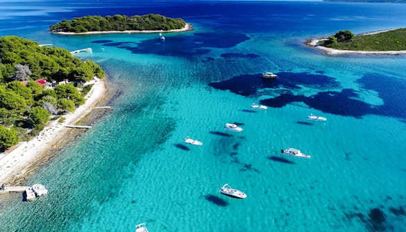 Aerial view of the Blue Lagoon with speedboats in turquoise water, surrounded by lush islands.