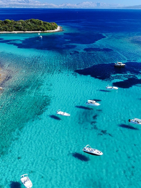 Aerial view of the Blue Lagoon with speedboats in turquoise water, surrounded by lush islands.