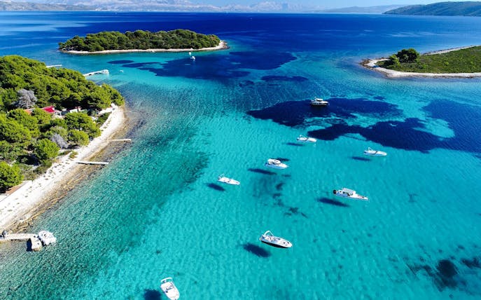 Aerial view of the Blue Lagoon with speedboats in turquoise water, surrounded by lush islands.