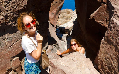 Guests hiking through rocky terrain on Santorini Volcanic cruise tour.