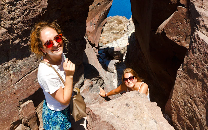Guests hiking through rocky terrain on Santorini Volcanic cruise tour.