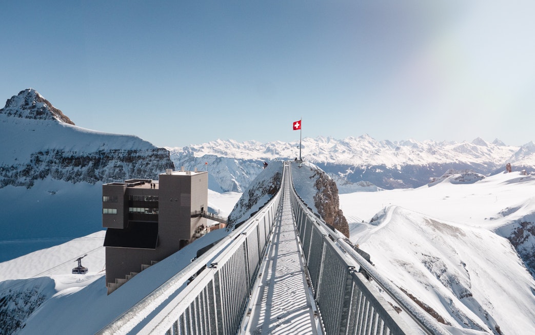 Suspension bridge at Glacier 3000 in Switzerland with snowy mountain views.
