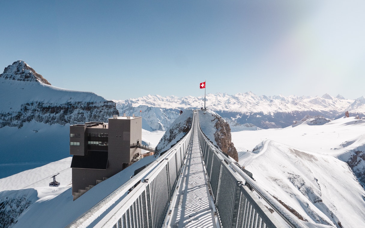Suspension bridge at Glacier 3000 in Switzerland with snowy mountain views.