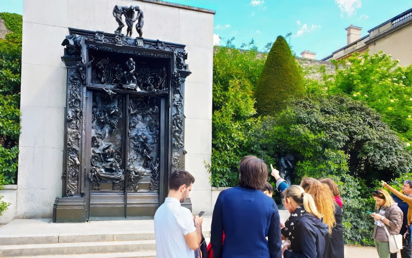 Visitors observing The Gates of Hell sculpture at Rodin Museum, Paris.