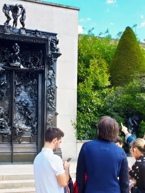 Visitors observing The Gates of Hell sculpture at Rodin Museum, Paris.