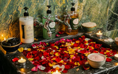 Traditional Moroccan hammam with rose petals, candles, and artisanal spa products.