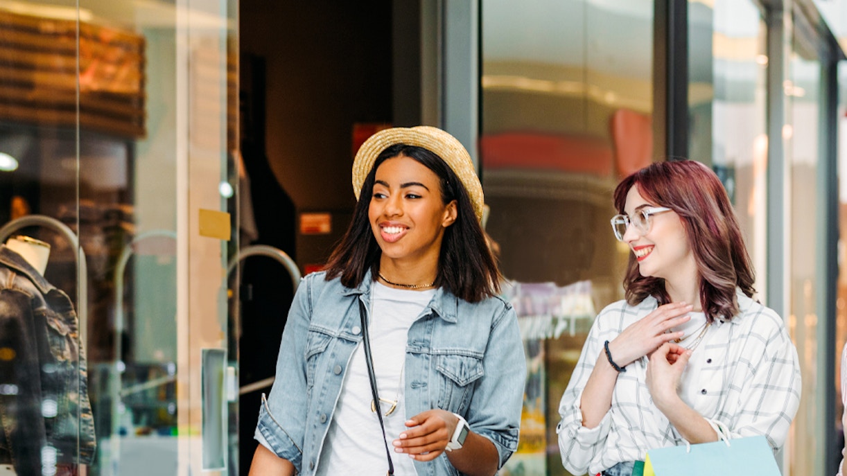 Women shopping and walking in a mall with shopping bags.