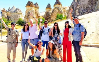 Group of tourists at Cappadocia's fairy chimneys during Red Tour, Turkey.