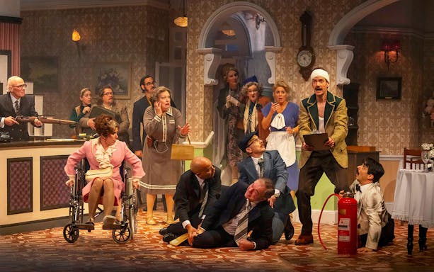 Theatrical scene depicting chaos in a hotel lobby, inspired by Fawlty Towers.