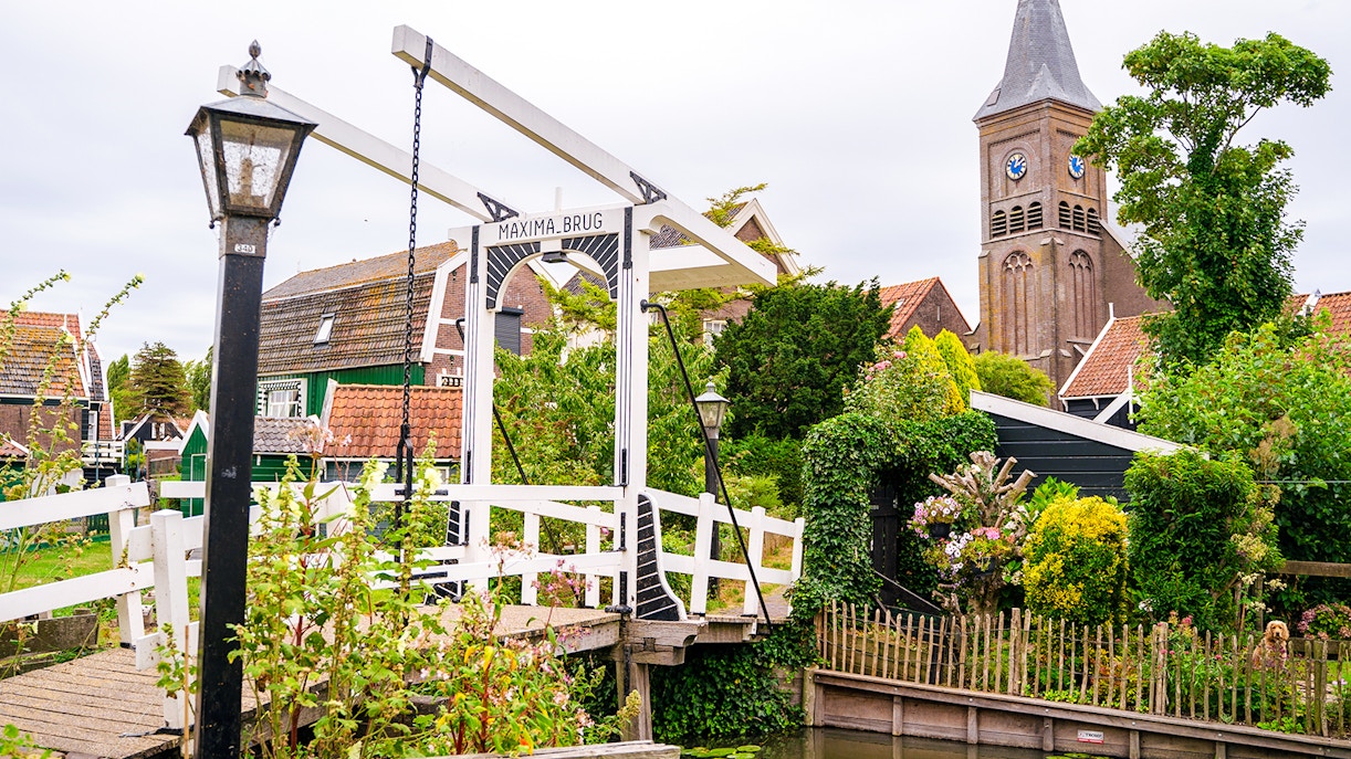Maxima Bridge in Marken, Netherlands, with church tower and traditional houses in the background.