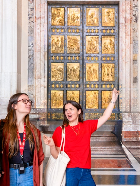 Tour guide explaining the Holy Door at St. Peter’s Basilica to visitors.
