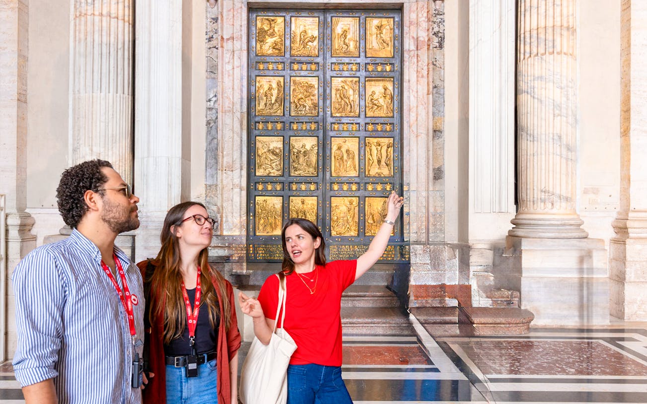 Tour guide explaining the Holy Door at St. Peter’s Basilica to visitors.