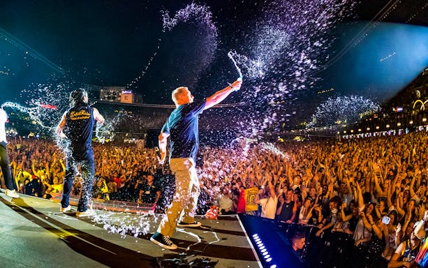 Performers spraying water over a crowd at UNTOLD Music Festival Dubai.