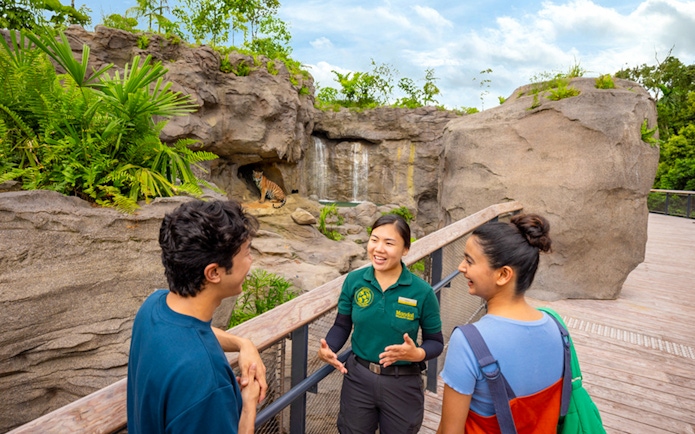 Guide explaining tiger habitat at Rainforest Wild Asia exhibit.