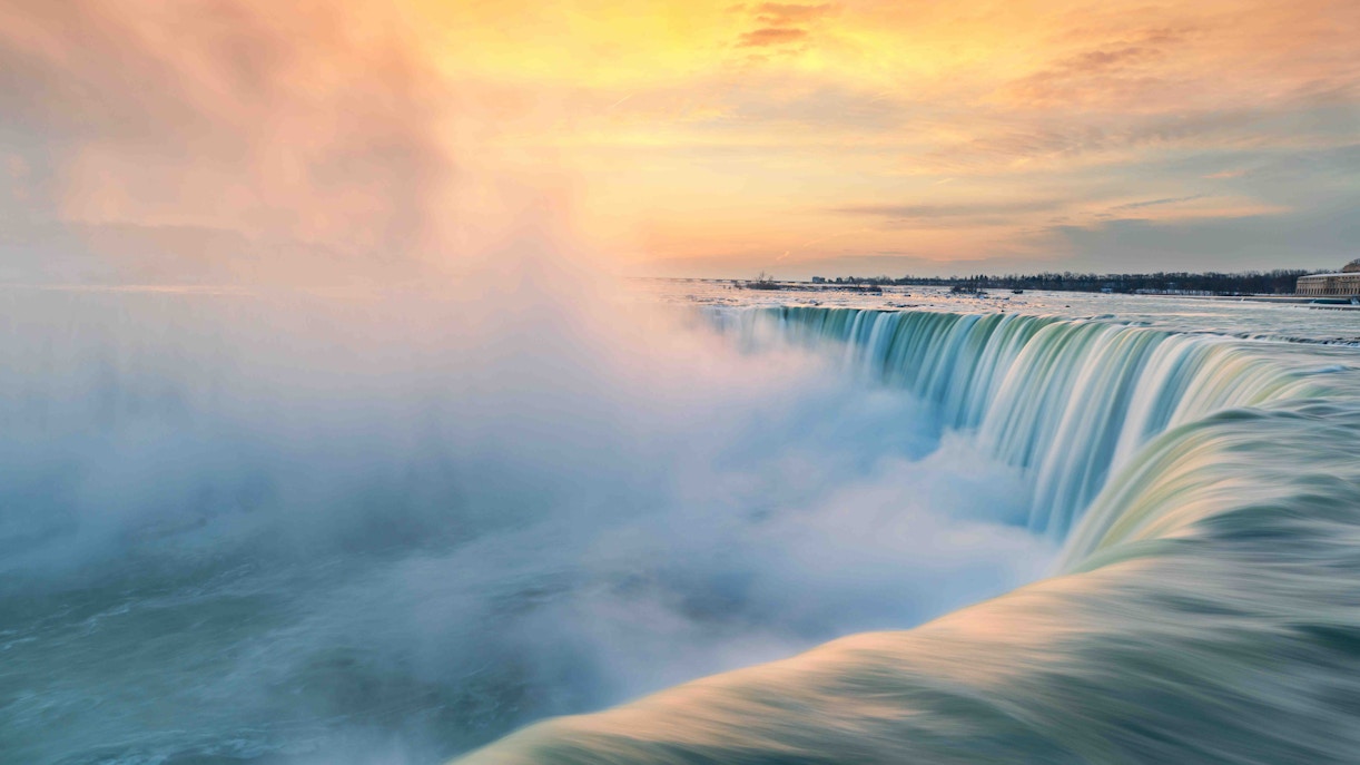 Niagara Falls morning view with mist rising, showcasing the iconic waterfall's grandeur.