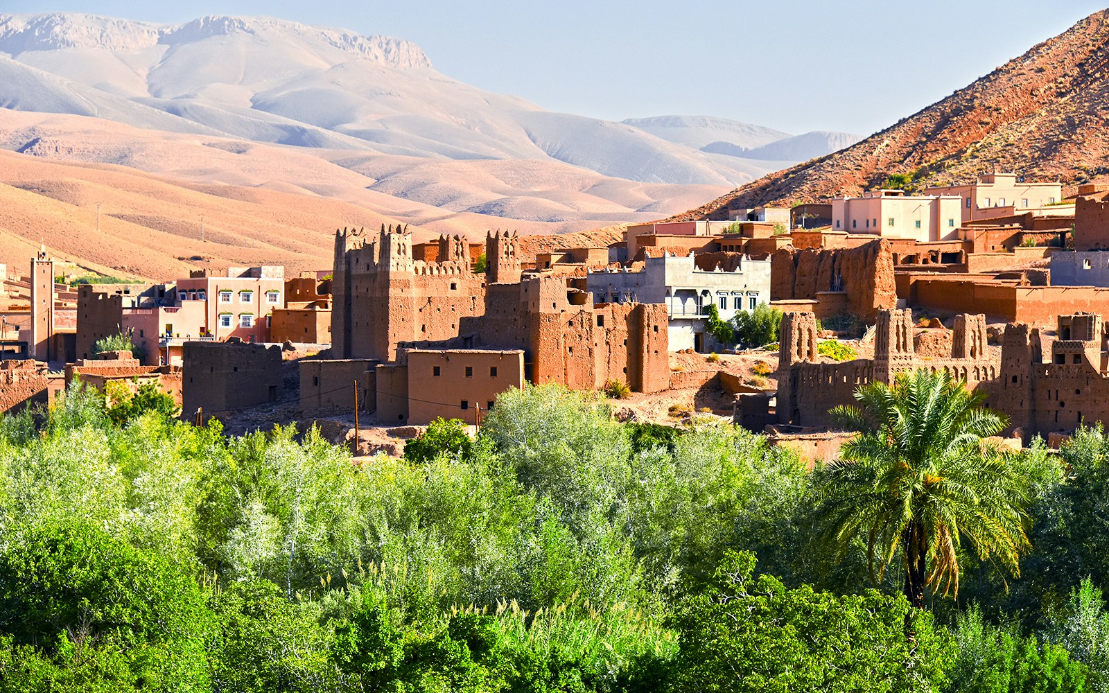 Old Berber architecture with palm trees near Tamellalt, Morocco.