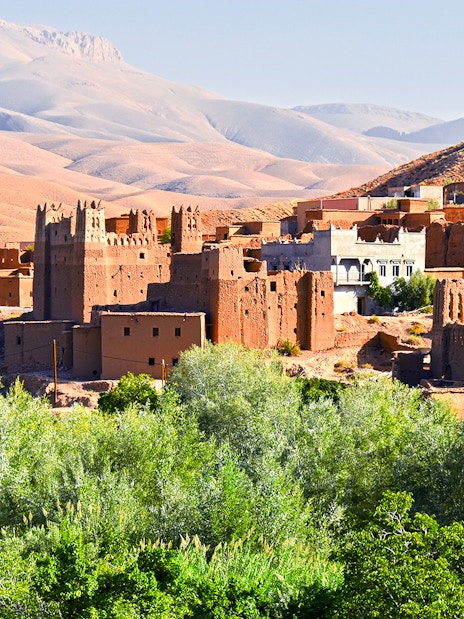 Old Berber architecture with palm trees near Tamellalt, Morocco.