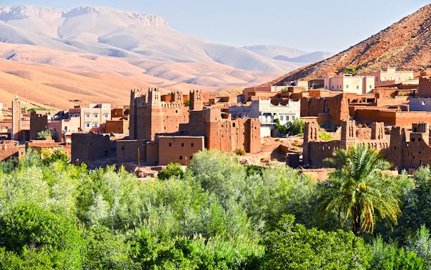 Old Berber architecture with palm trees near Tamellalt, Morocco.