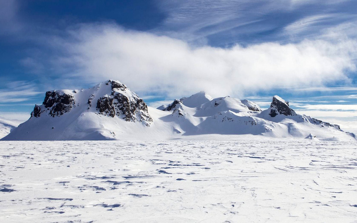 Langjökull Glacier's snowy peaks under a clear blue sky in Iceland.
