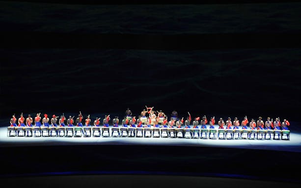 Performers on a multi-lifting platform in a synchronized drumming show.