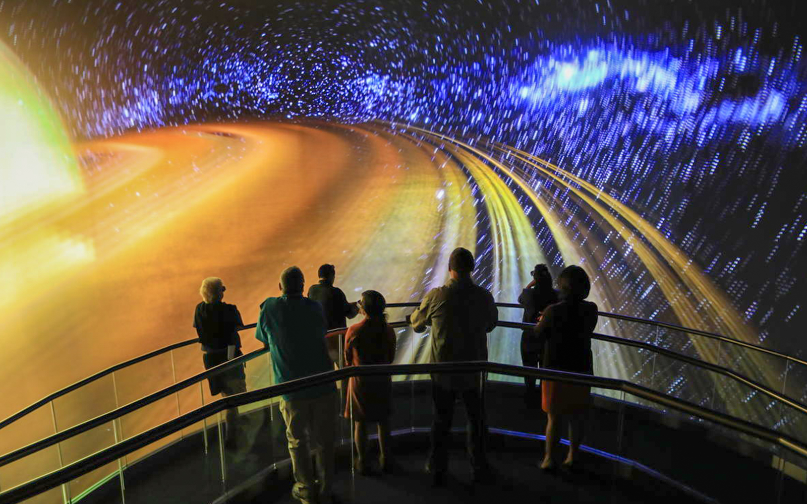 Visitors viewing space-themed projection at Heroes and Legends Exhibit, Kennedy Space Center.
