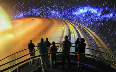 Visitors viewing space-themed projection at Heroes and Legends Exhibit, Kennedy Space Center.