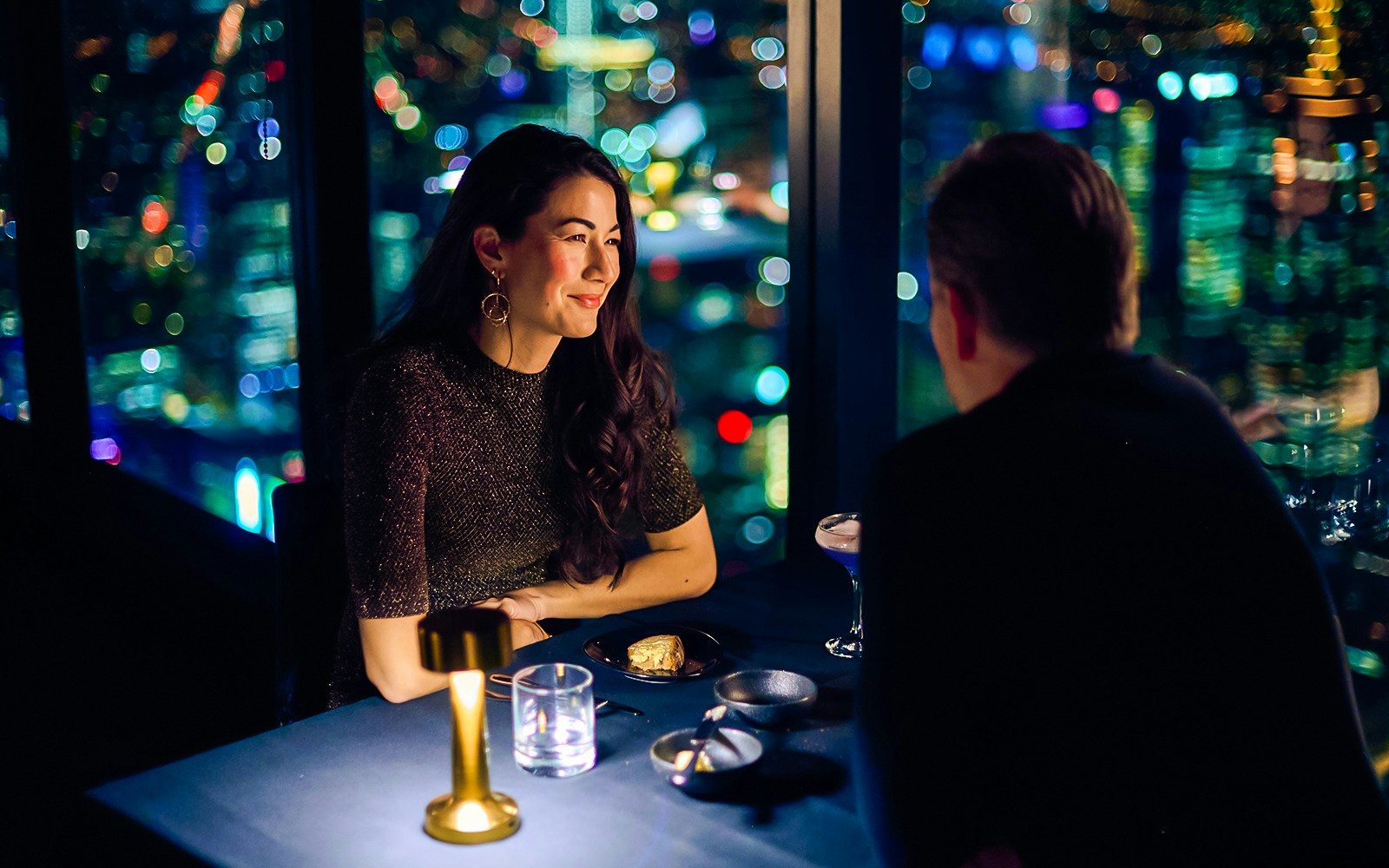 Couple dining at Melbourne Skydeck with city lights view.