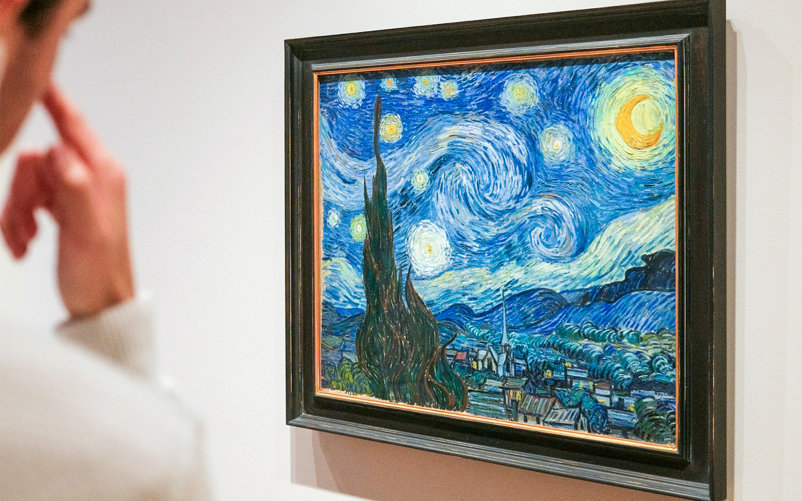 Person viewing Van Gogh's "Starry Night" at Orsay Museum, Paris.