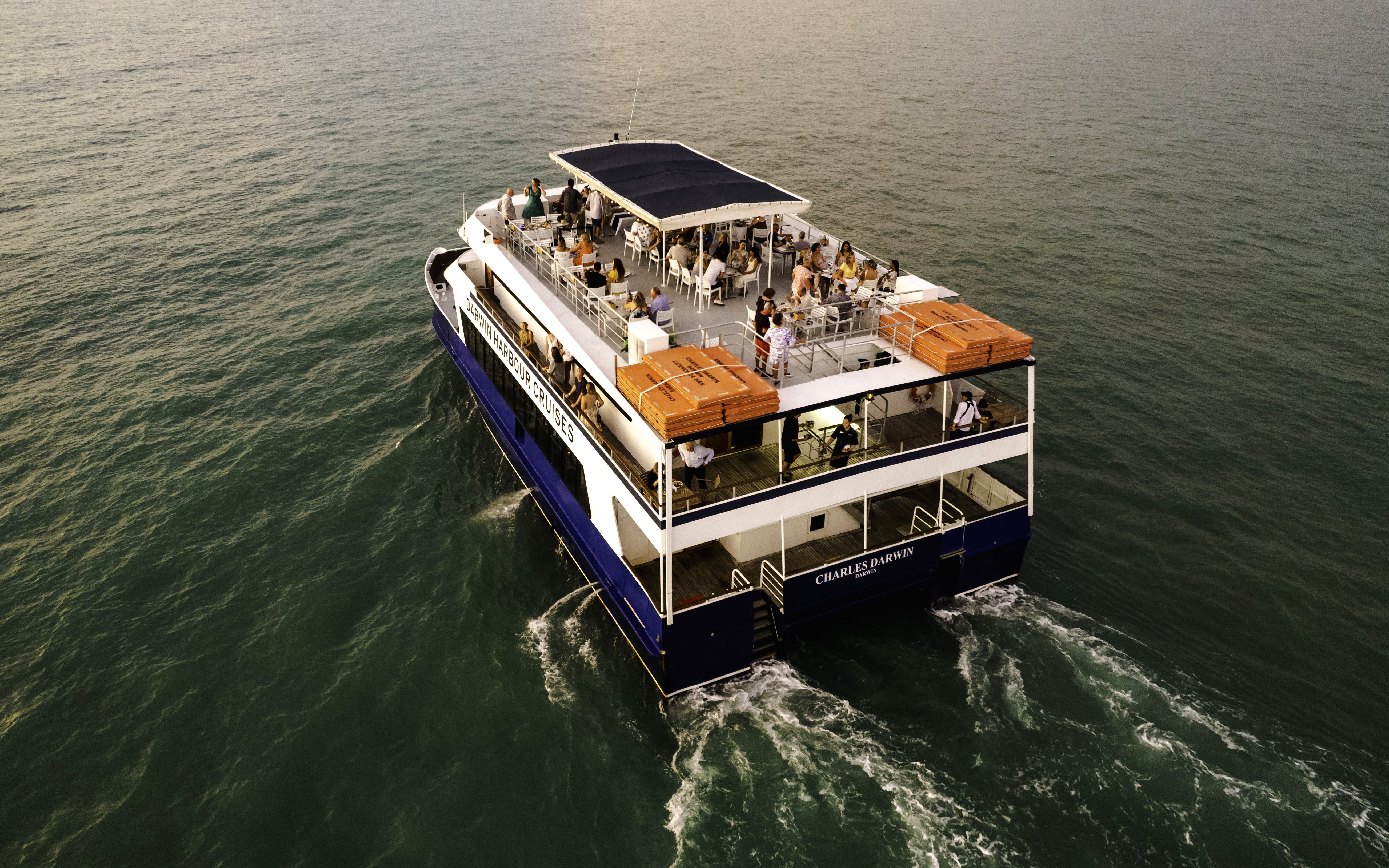 Darwin Harbour cruise ship with passengers enjoying a sunset dinner.