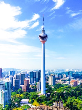 KL Tower rising above Kuala Lumpur skyline with surrounding cityscape.