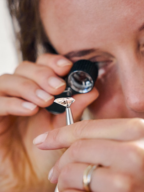 Guest examining a diamond with a loupe at Royal Coster Diamond Experience, Amsterdam.