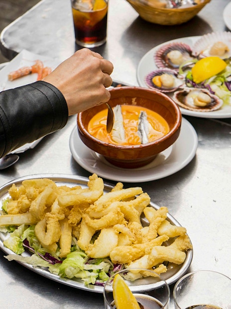 Participants enjoying seafood dishes on a Tapas Tasting Tour in Seville.