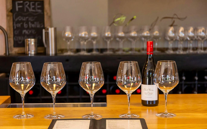 Wine glasses and a bottle on a tasting counter in Queenstown winery.