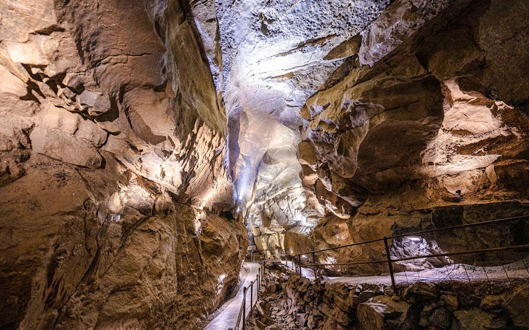 Aillwee Caves passageway with illuminated rock formations in County Clare, Ireland.